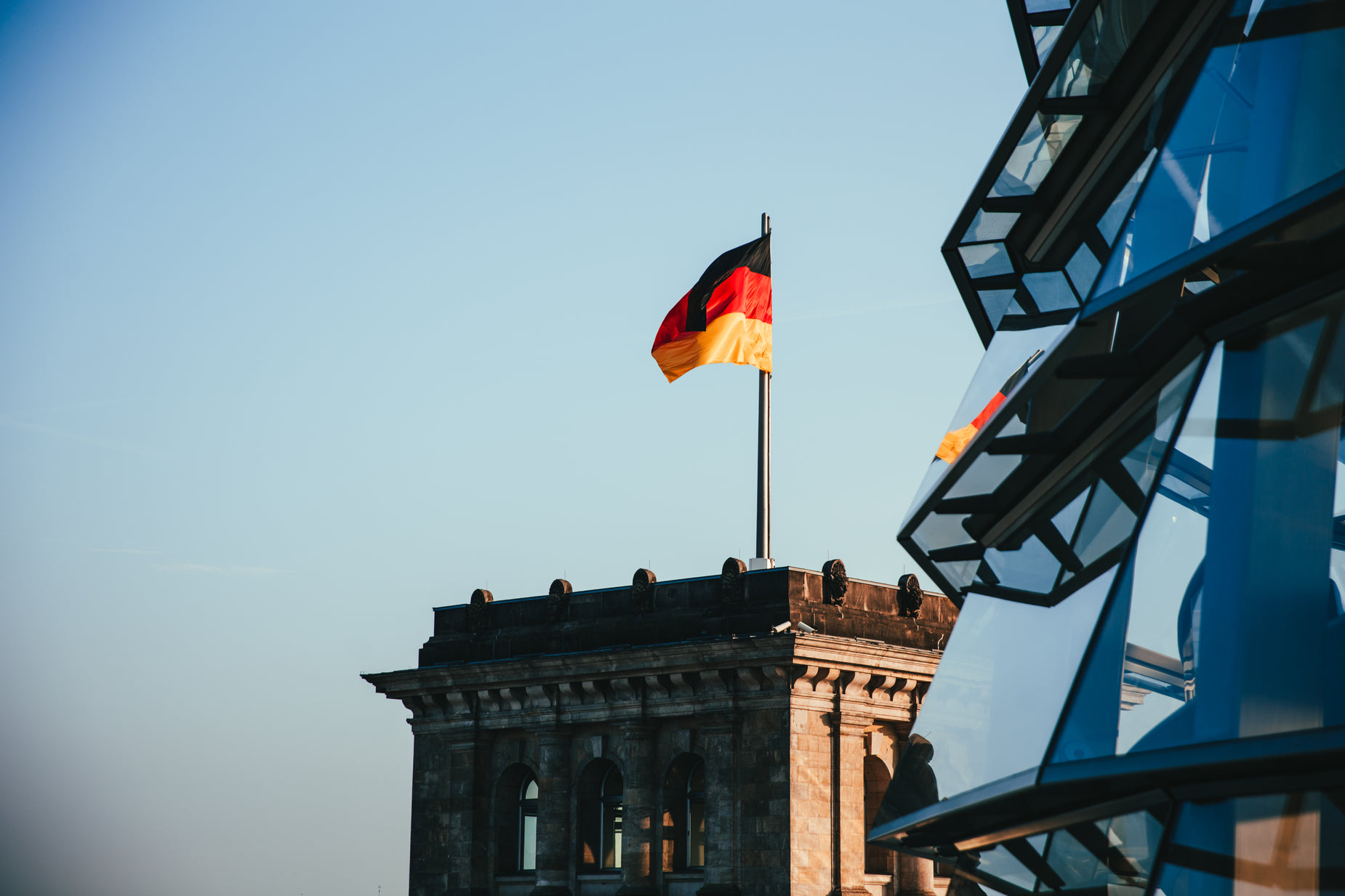 the german flag flies in front of an old building