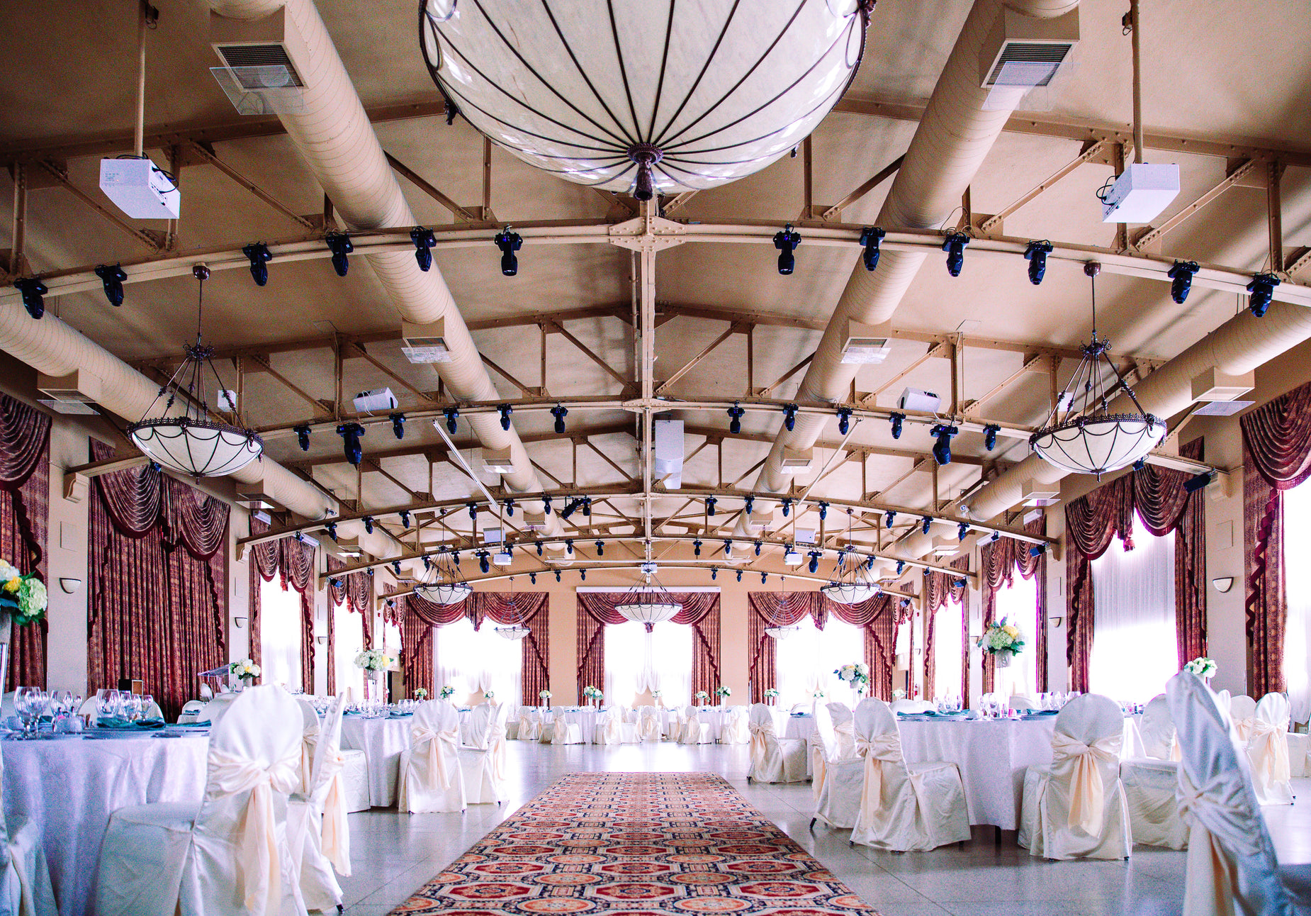 an ornate room is adorned with chandeliers and white linens