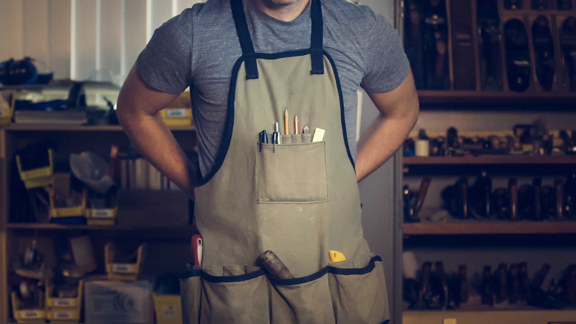 man in work attire wearing tools on both hands