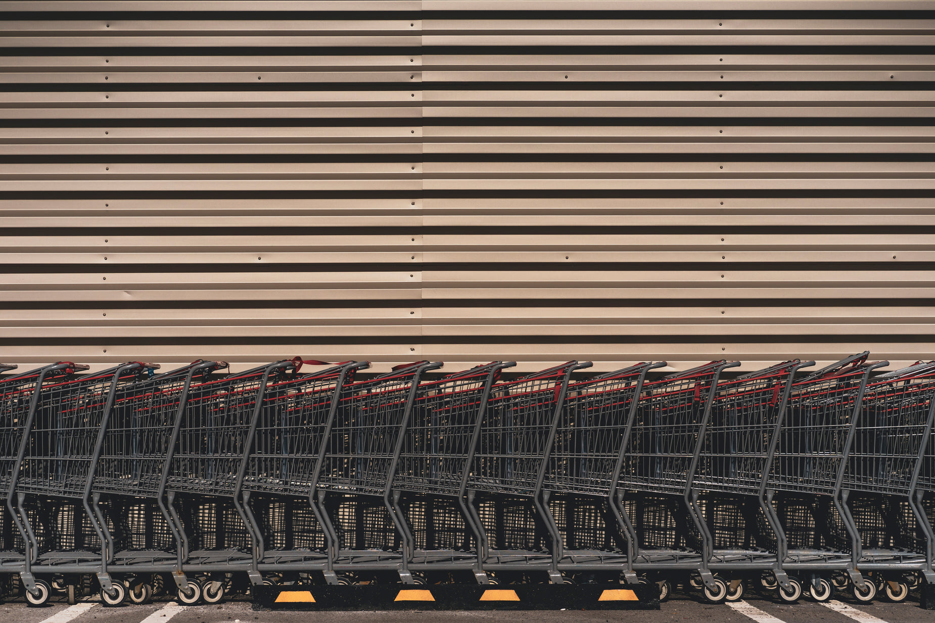 a row of shopping carts lined up near a large building