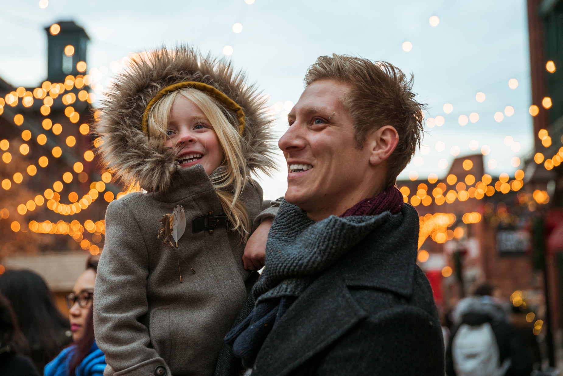 a man and a young woman in a city setting for a christmas ornament display