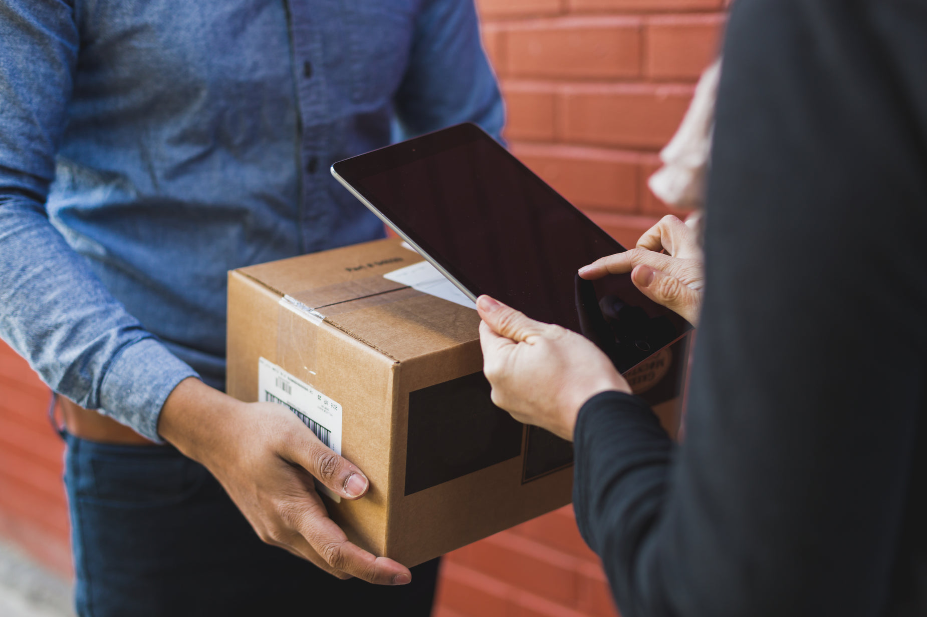 a woman handing a box to another person