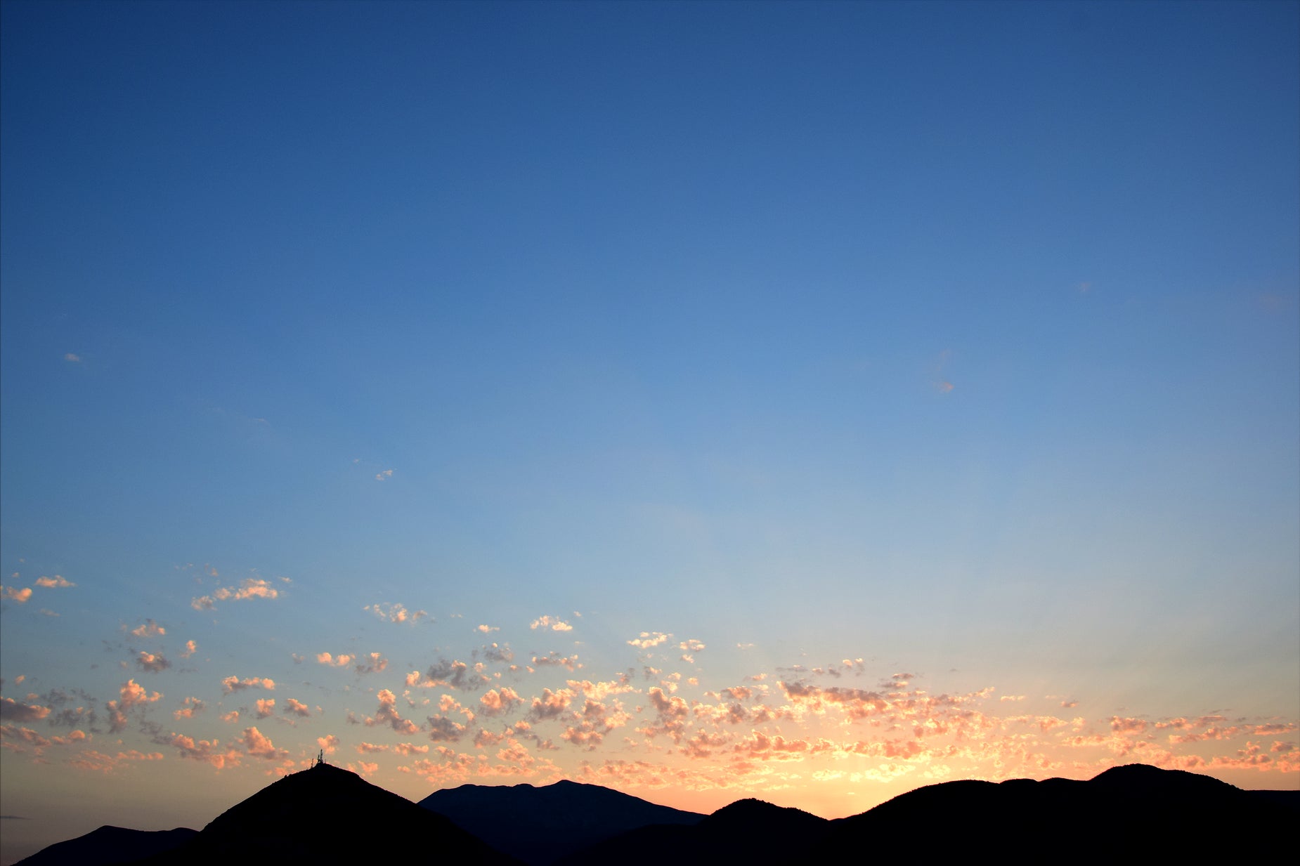 a clear sky with some clouds and a few animals