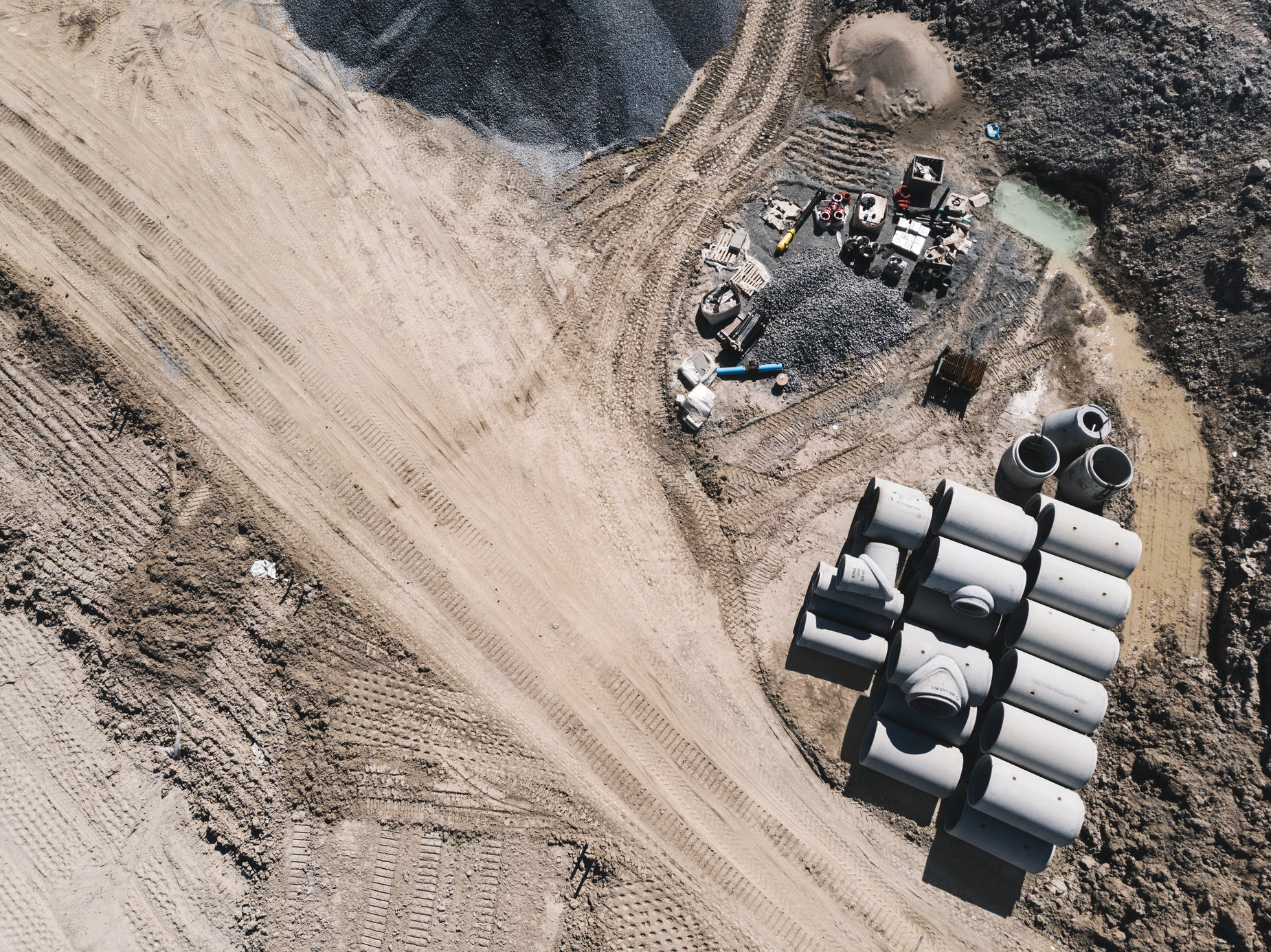 several large pipe structures next to a truck and some sand