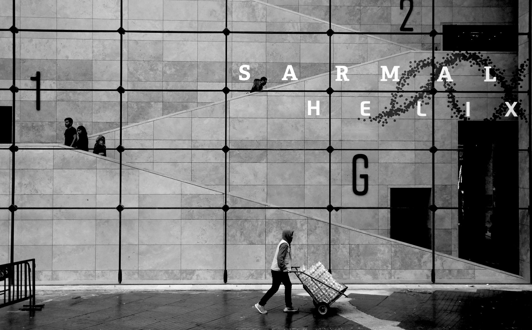 a woman hing a grocery cart through a commercial building