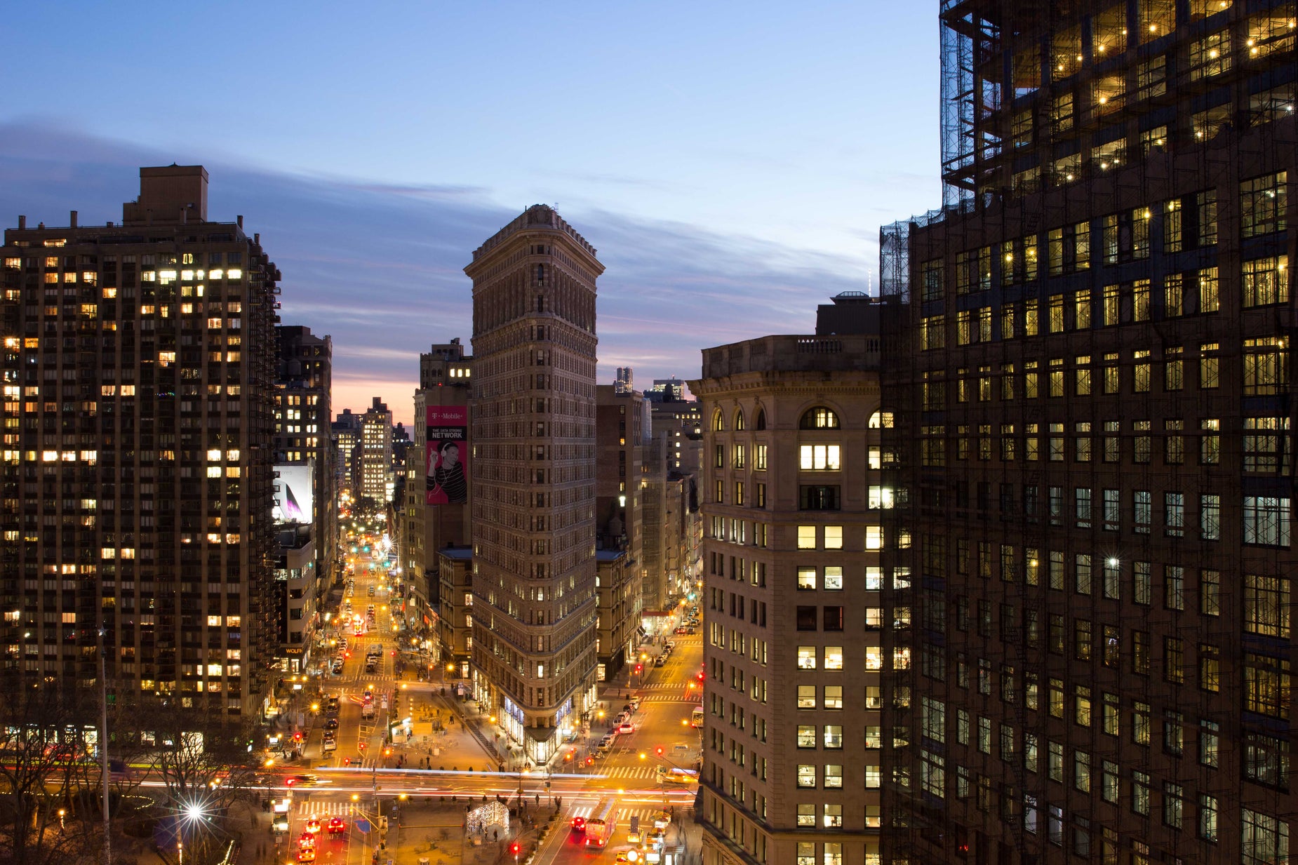 a city street is lined with tall buildings