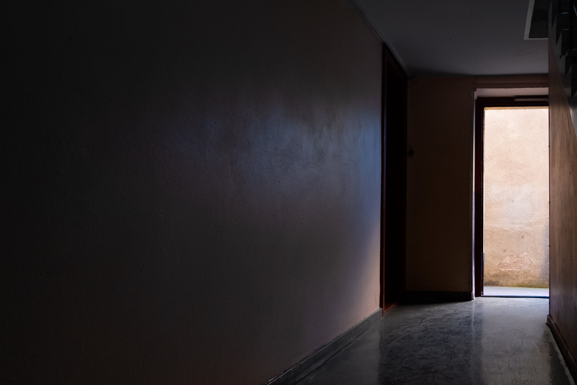 a dark hallway leading to an open door