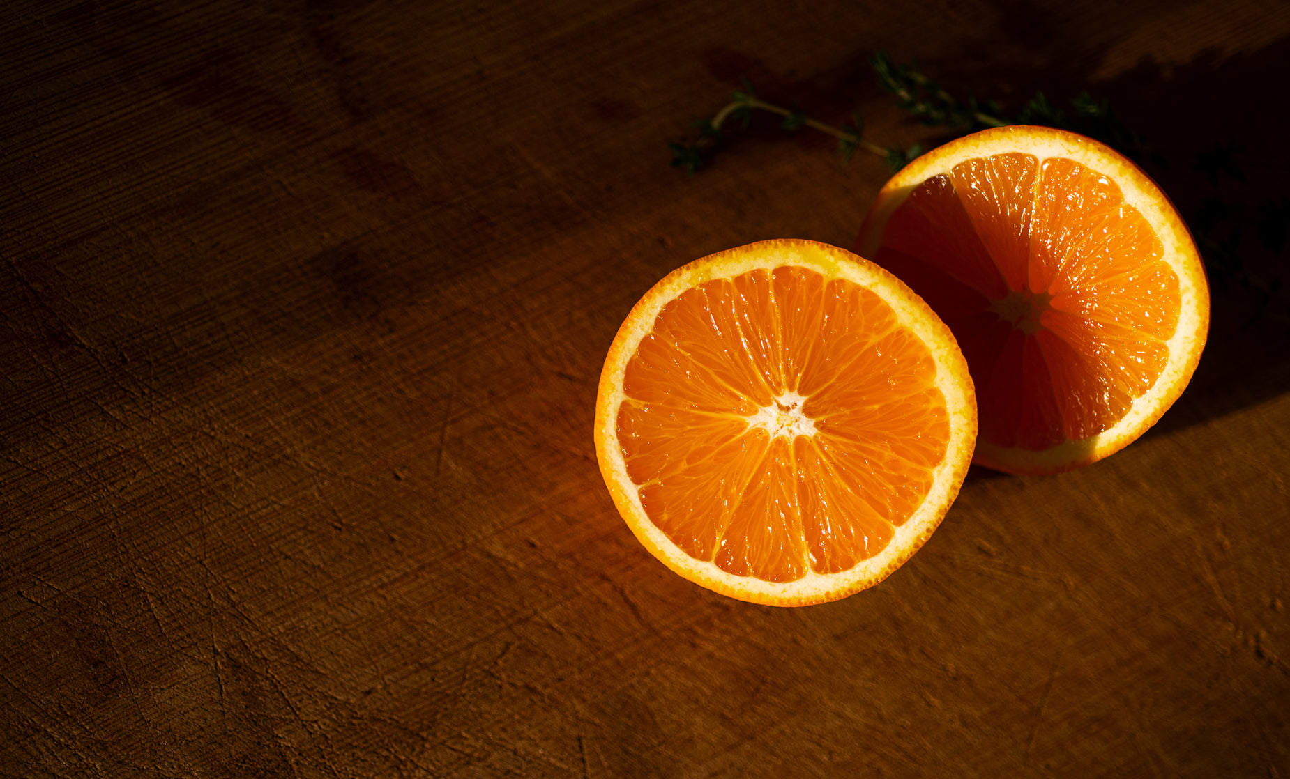 an orange is sliced in half on a wooden surface