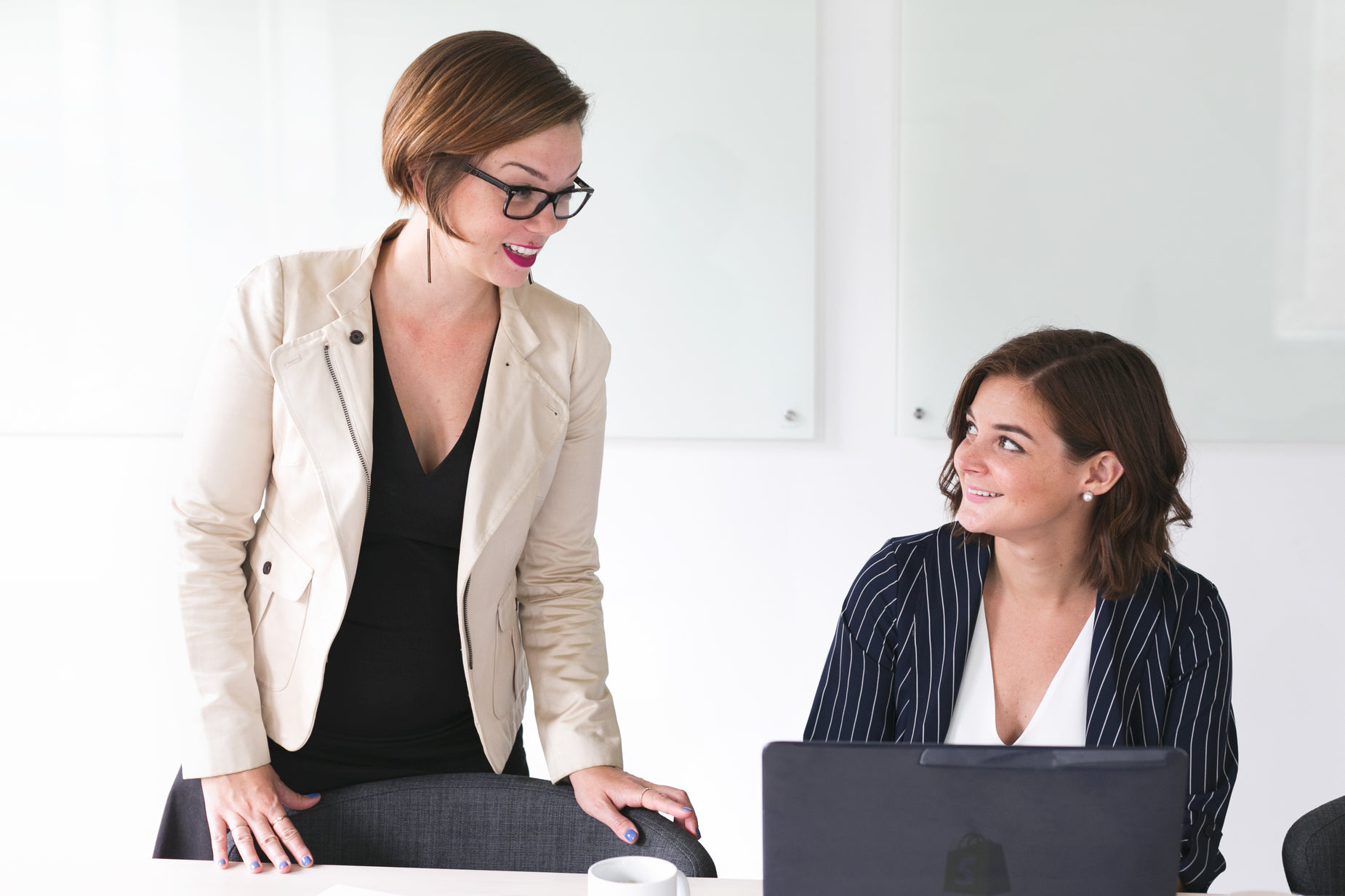 two women sitting at a table and having conversation with each other