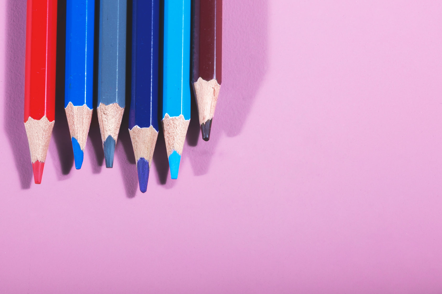 six pencils in four colors leaning on the wall
