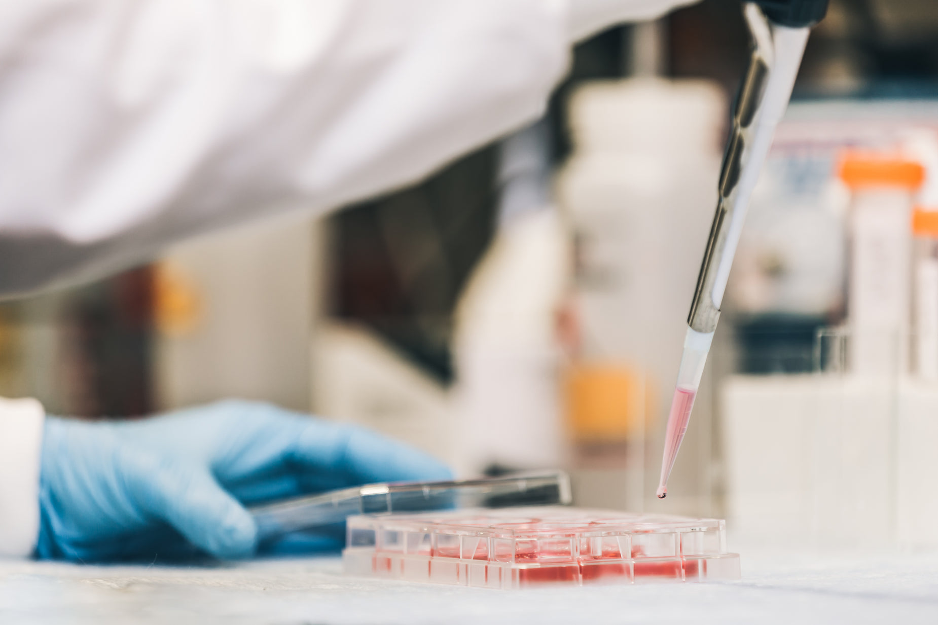 a hand is working on a test tube with a needle