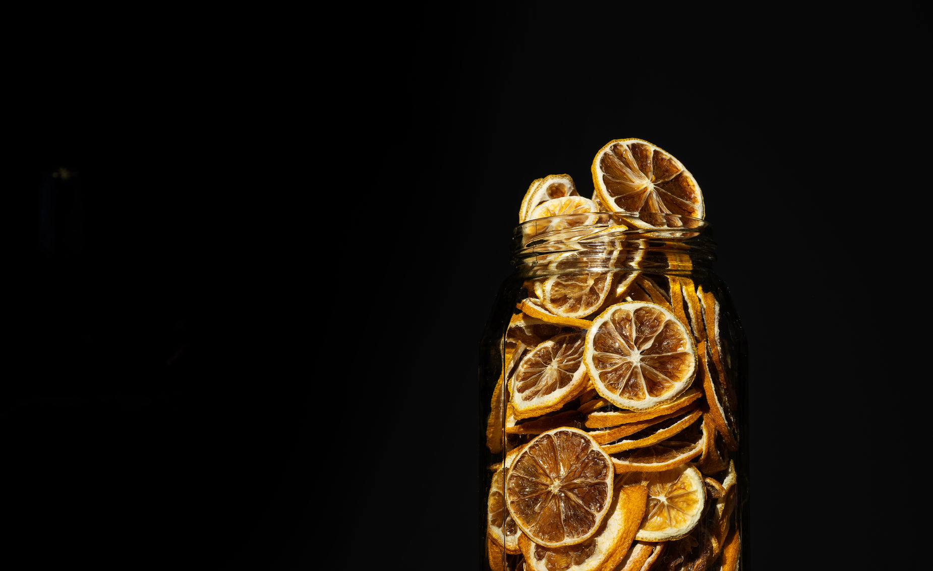 a jar full of sliced oranges with some lemons