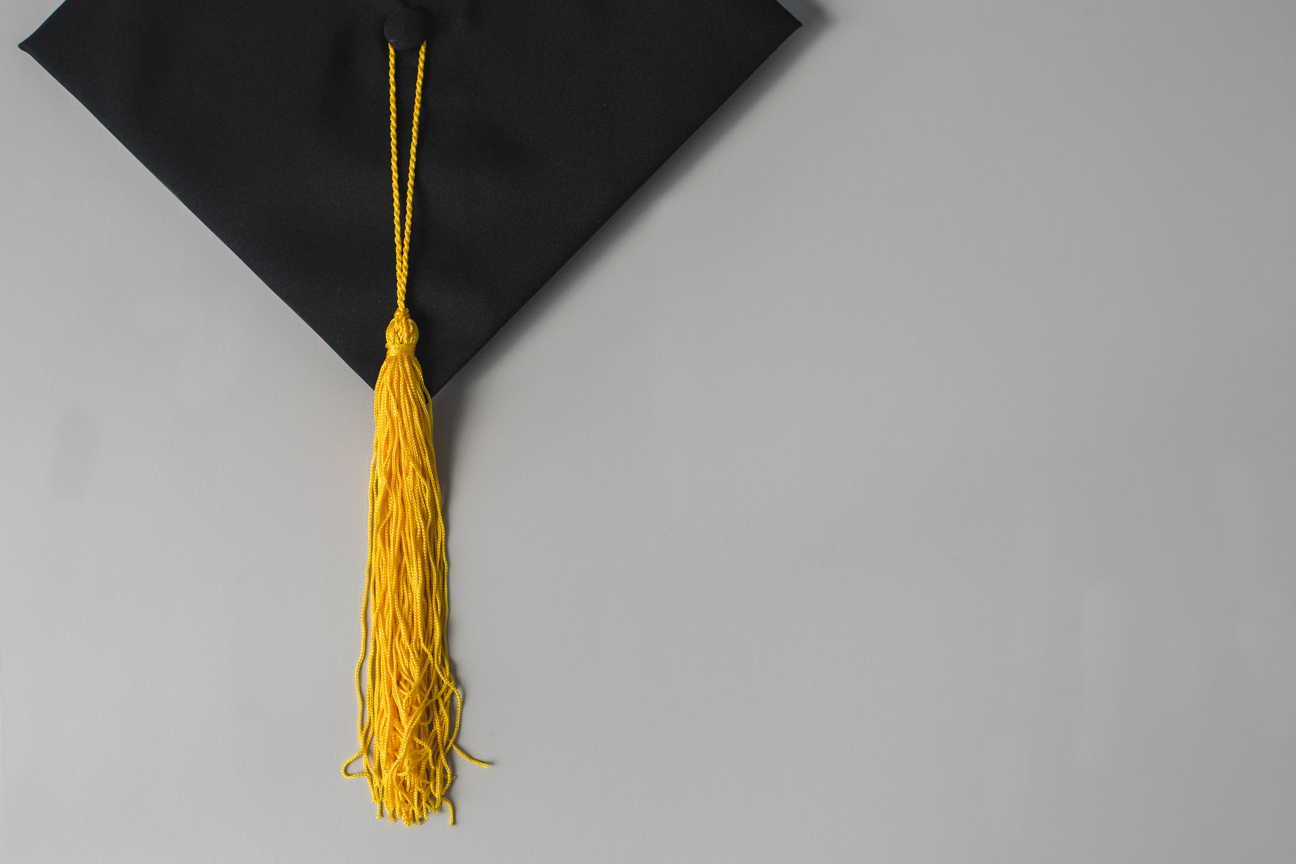 a black graduation cap with a golden tassel