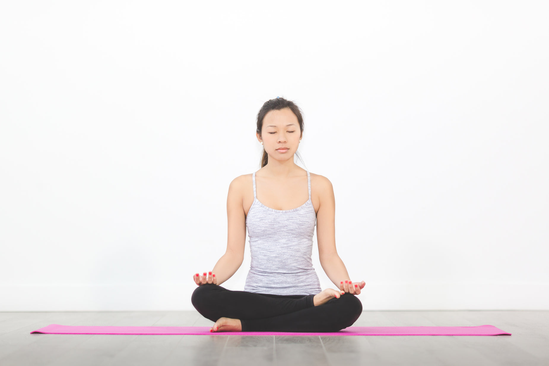 a woman sits in a lotus position with her eyes closed