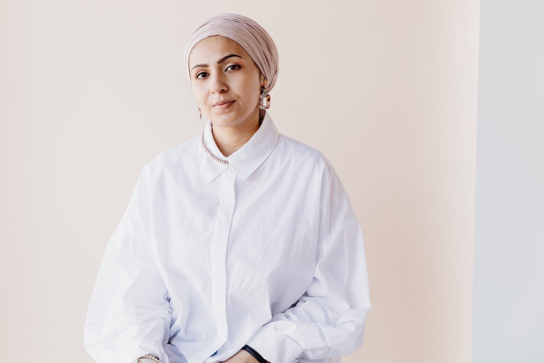 a young woman poses in a white shirt