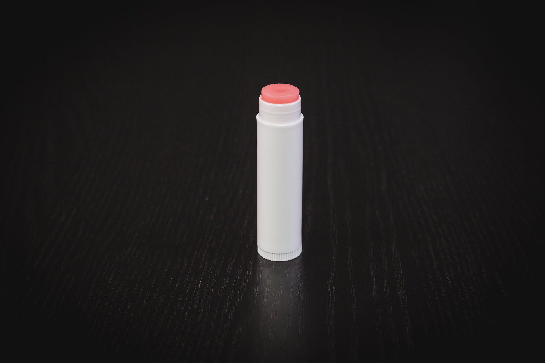 a white lighter sitting on a dark table