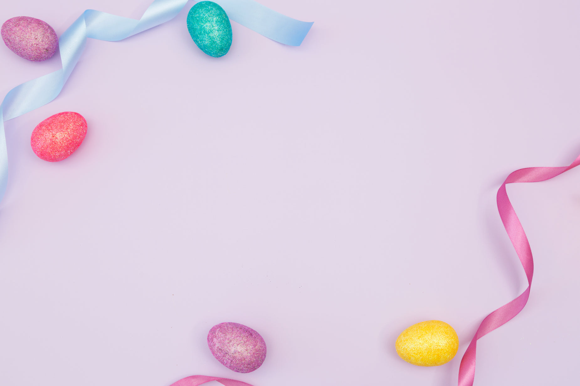 decorative painted eggs and ribbons against pink background