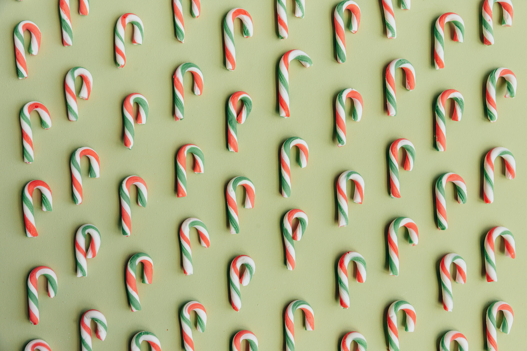 several candy canes in different shapes and sizes on a green background