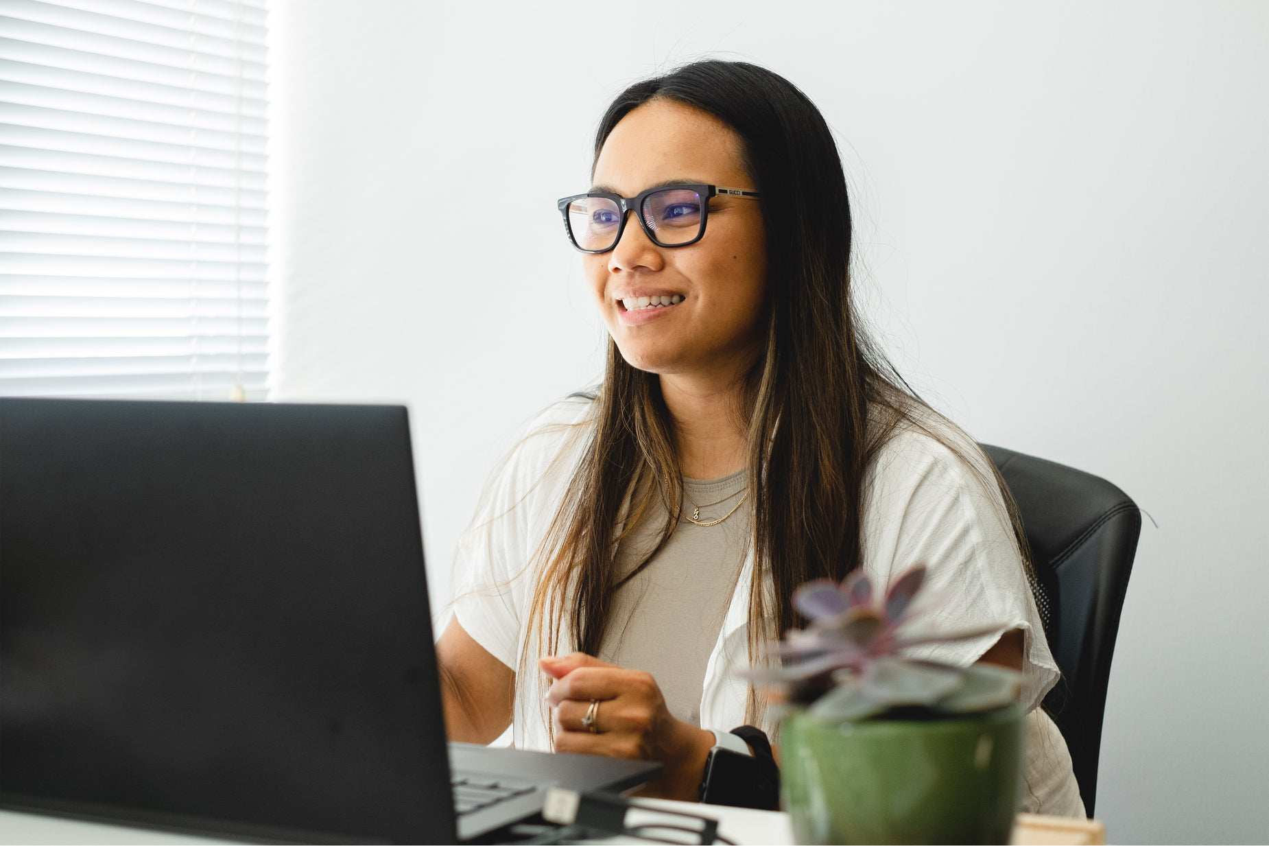 the lady is sitting in front of a laptop computer