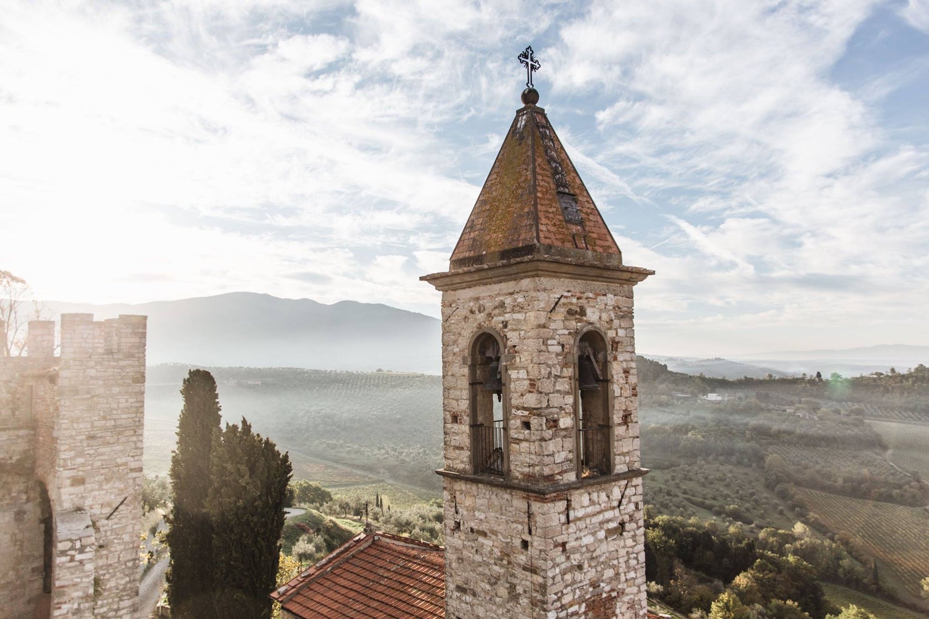 the sun is shining on a tower near mountains