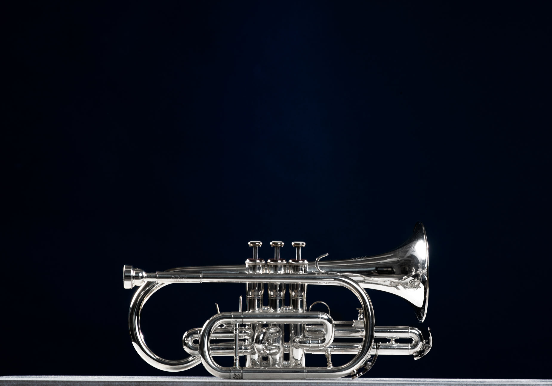 a trumpet with clear bell stands on top of a wooden stand
