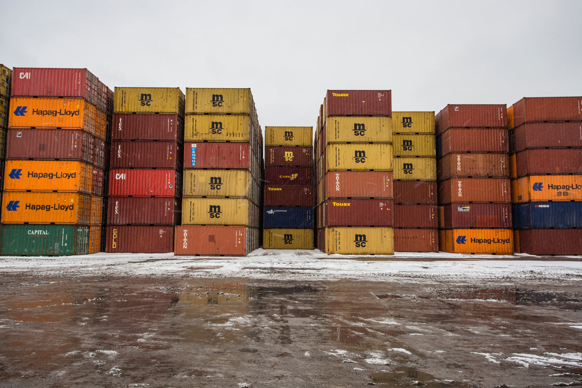 the cargo truck is moving behind stacks of boxes