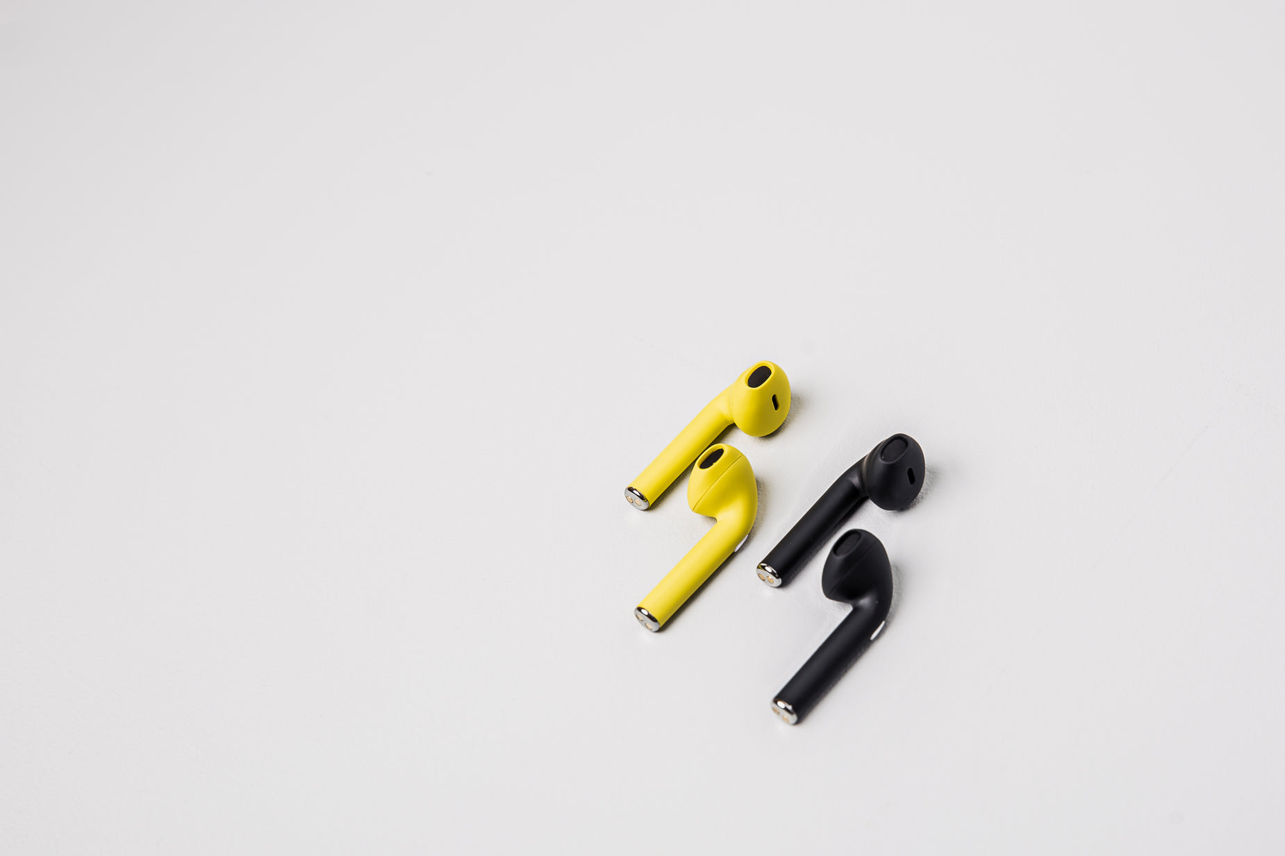 two earphones are shown with yellow ear buds