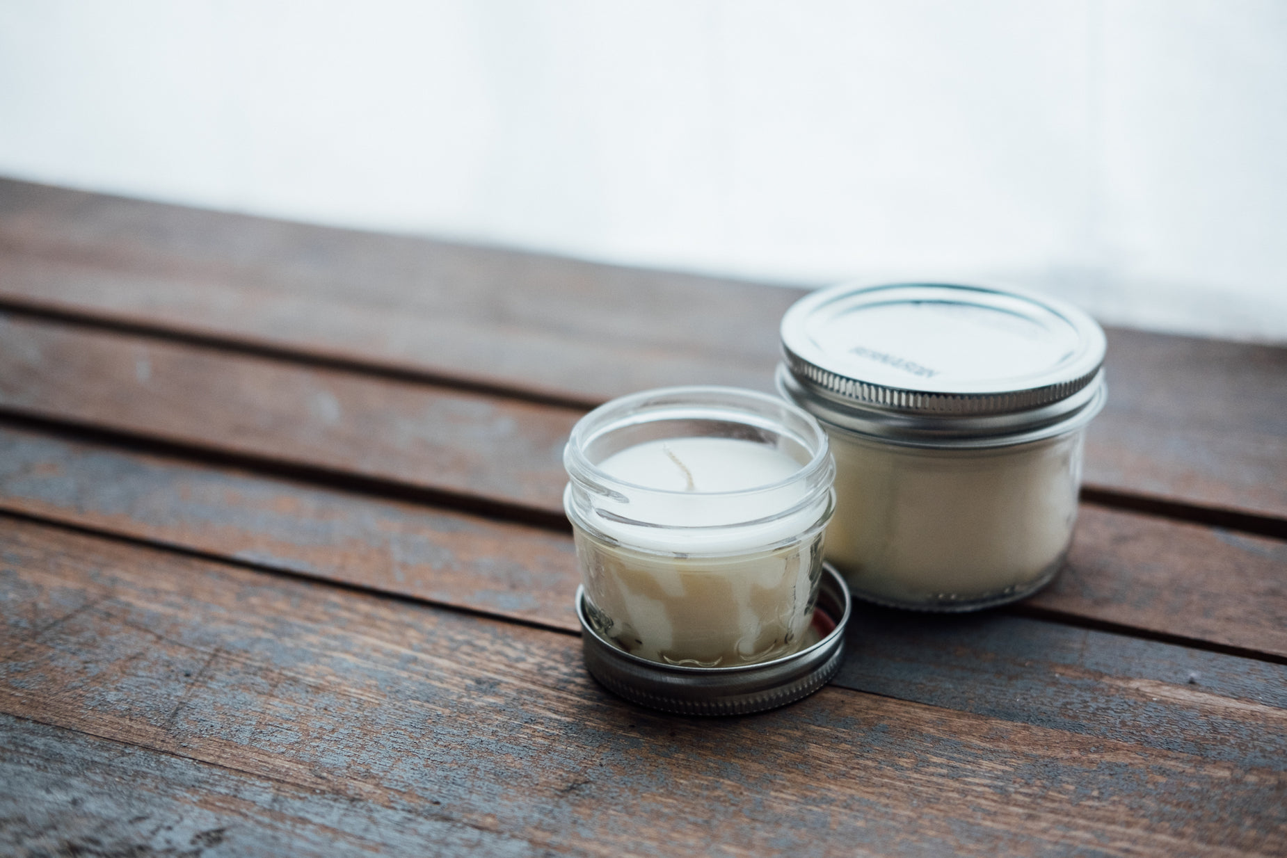 two empty jars sitting on top of a wooden table