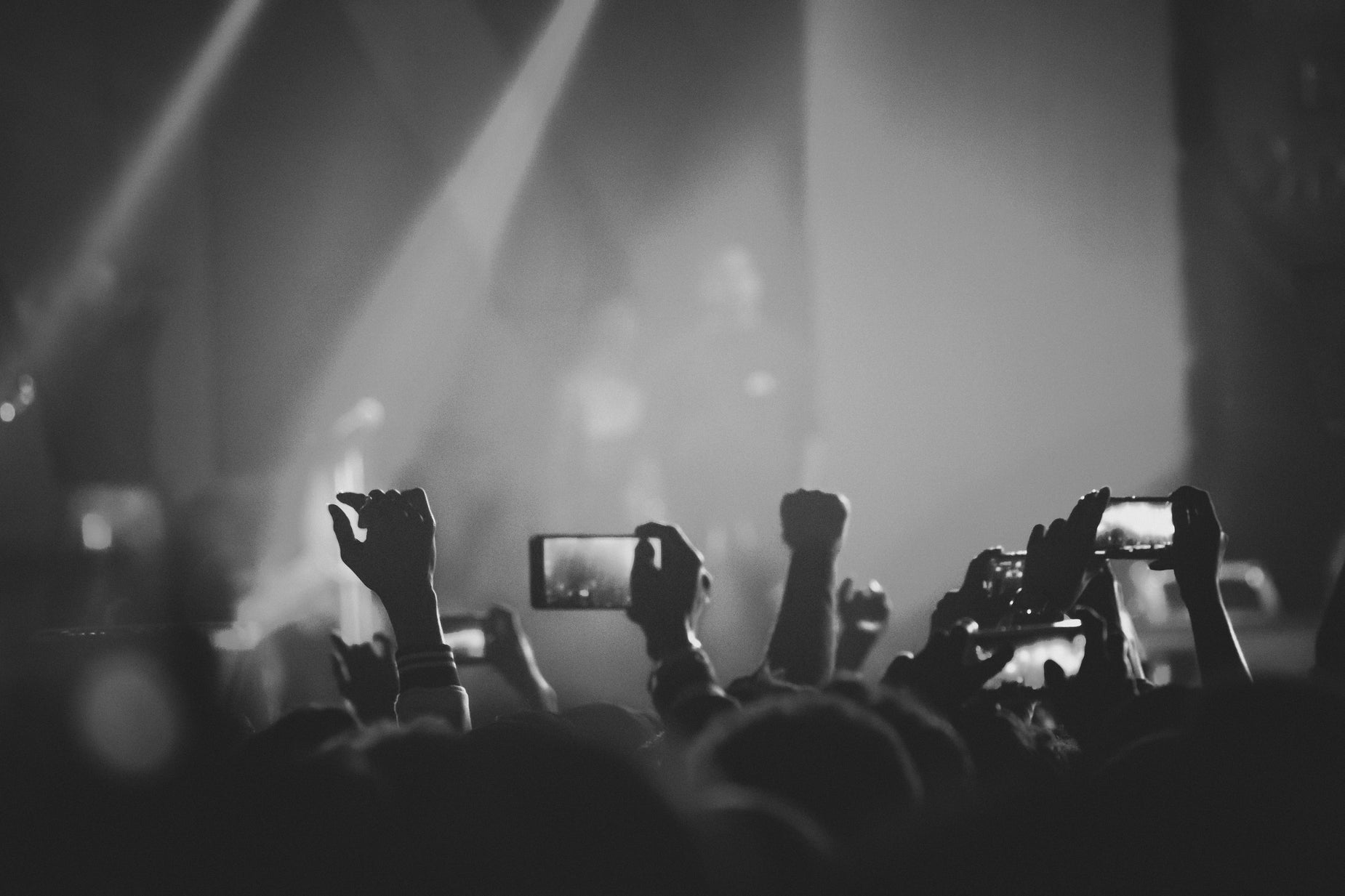 a group of people holding up cell phones in front of a stage