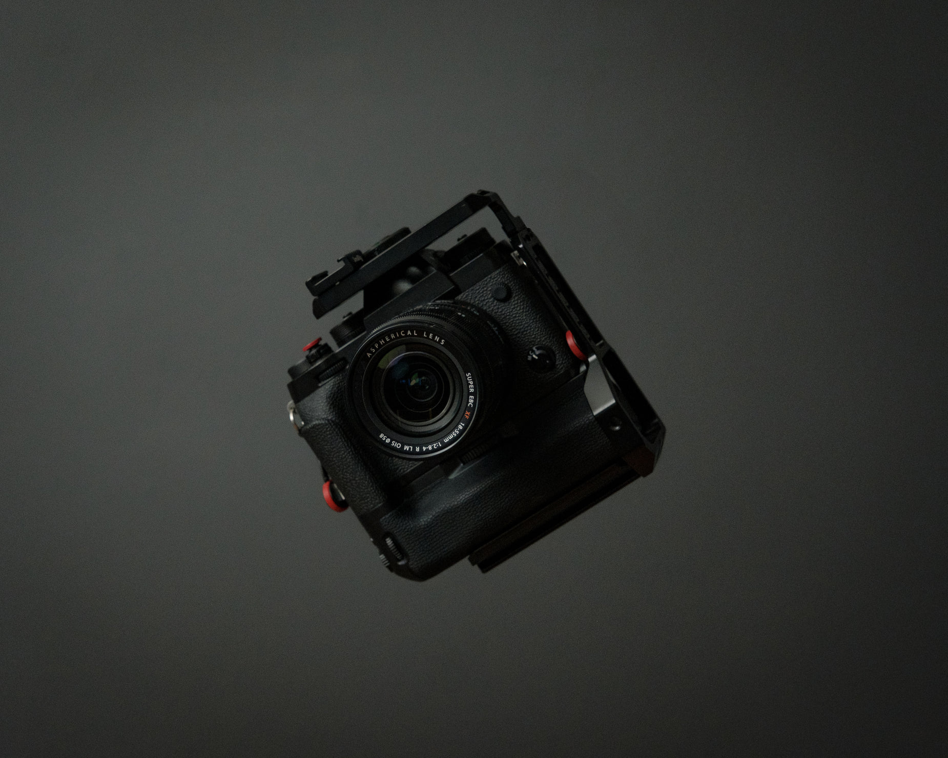 an analog camera is seen from above, on the dark surface