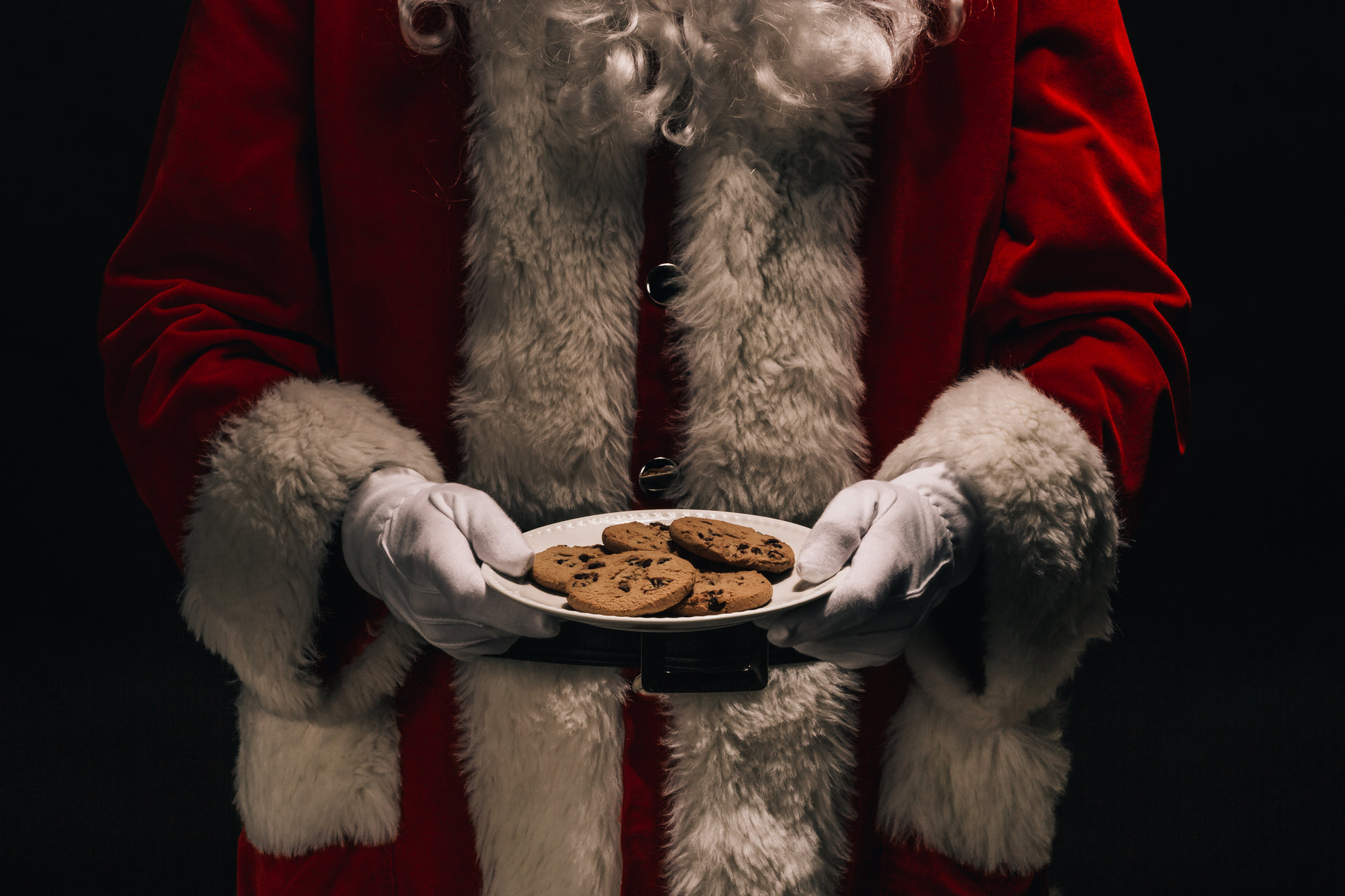 santa claus holding a plate of cookies in his hands