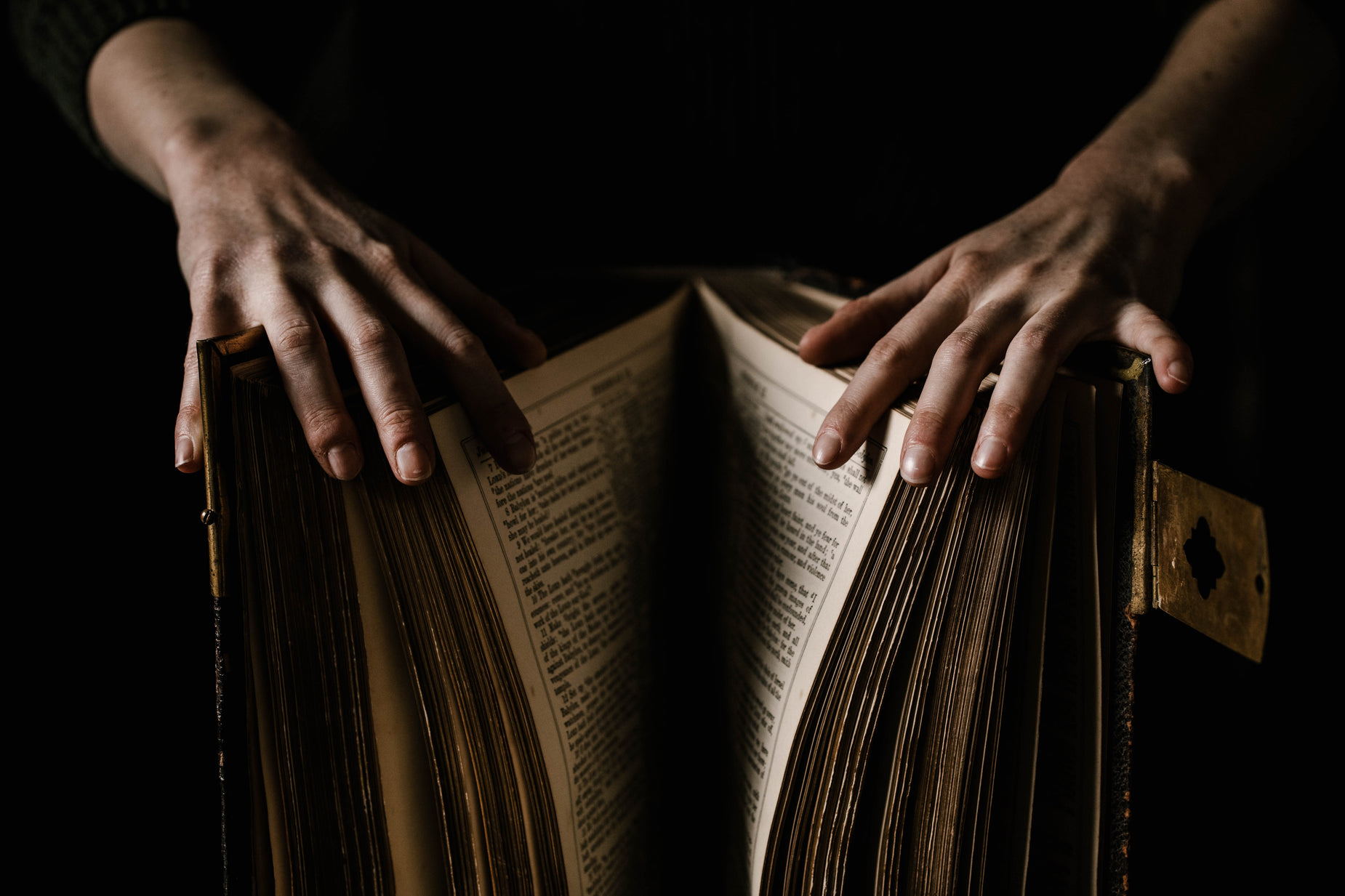 a person reading an open book with hands and pages