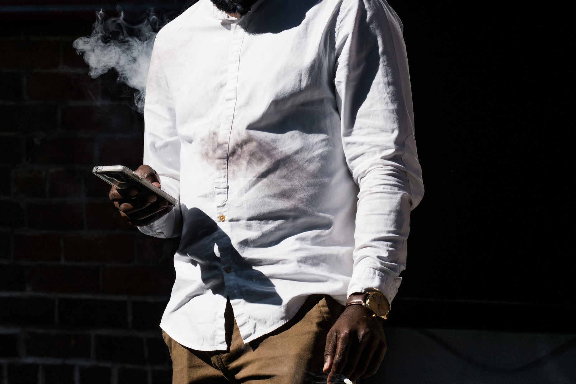 a person standing on the street holding onto a cigarette