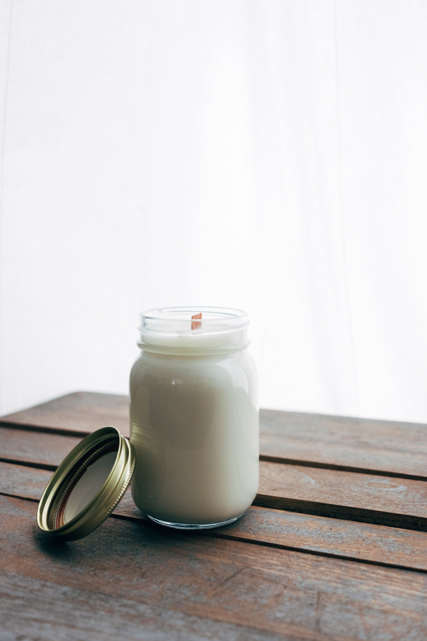 a jar with white liquid sitting on a wooden table