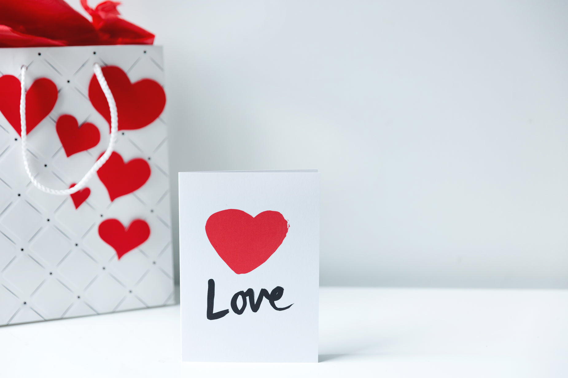 a card with a love tag on the front, and a small bag that has a large heart on it