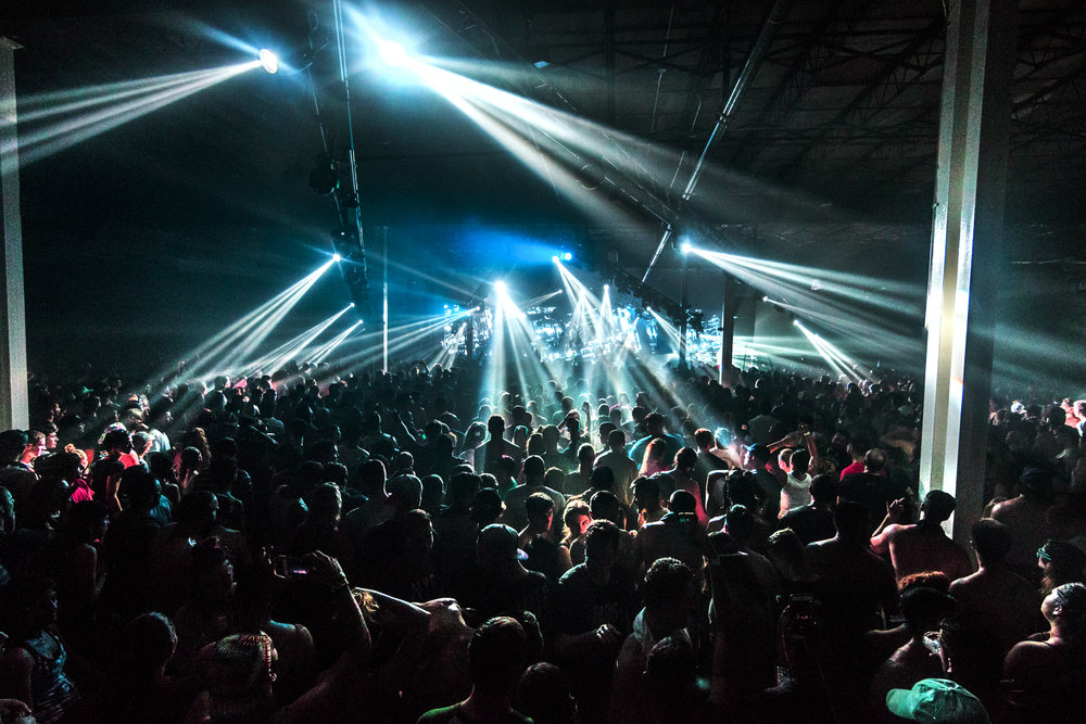 people standing at a concert lit up by white and blue lights