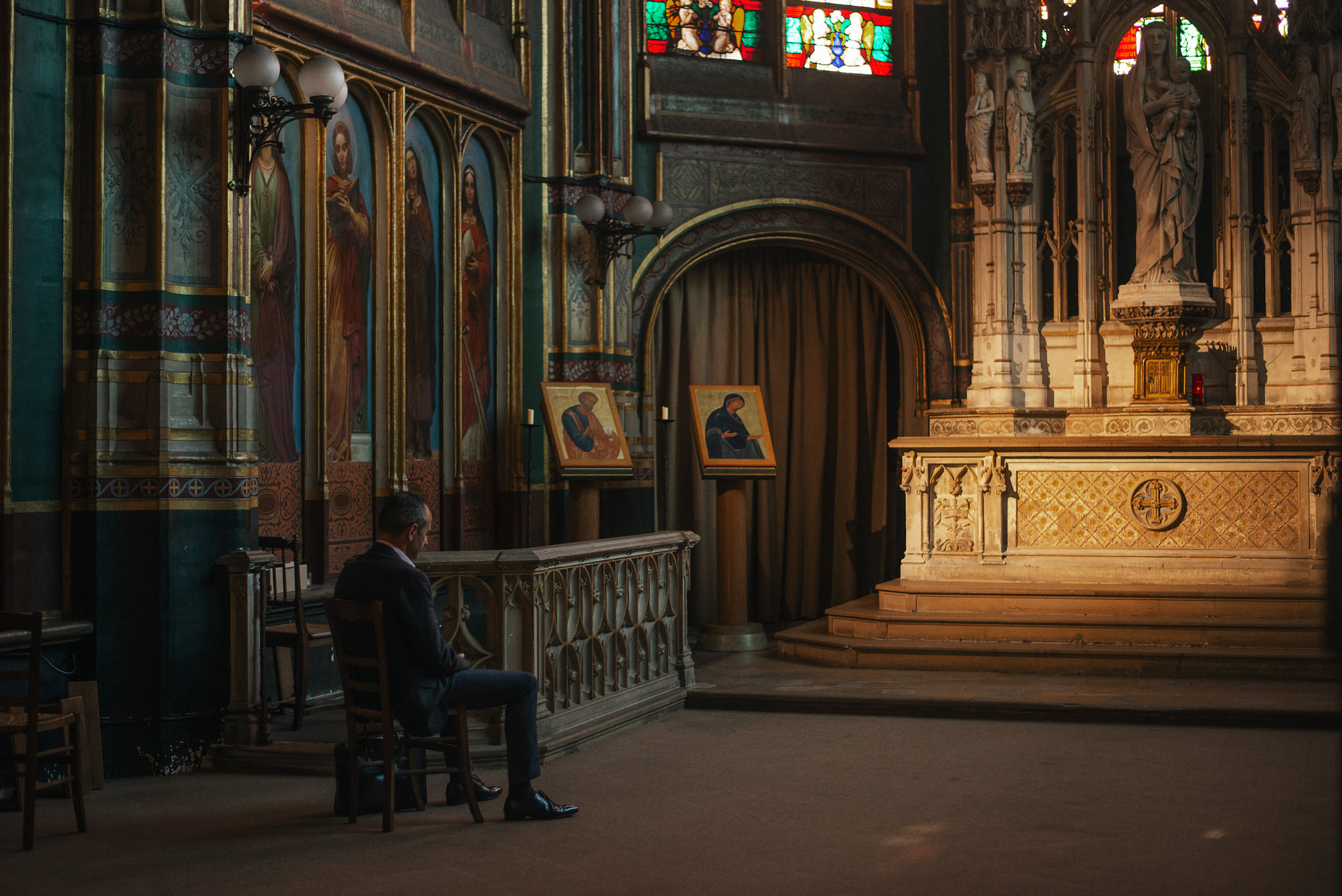 a person sitting at a alter of an old building