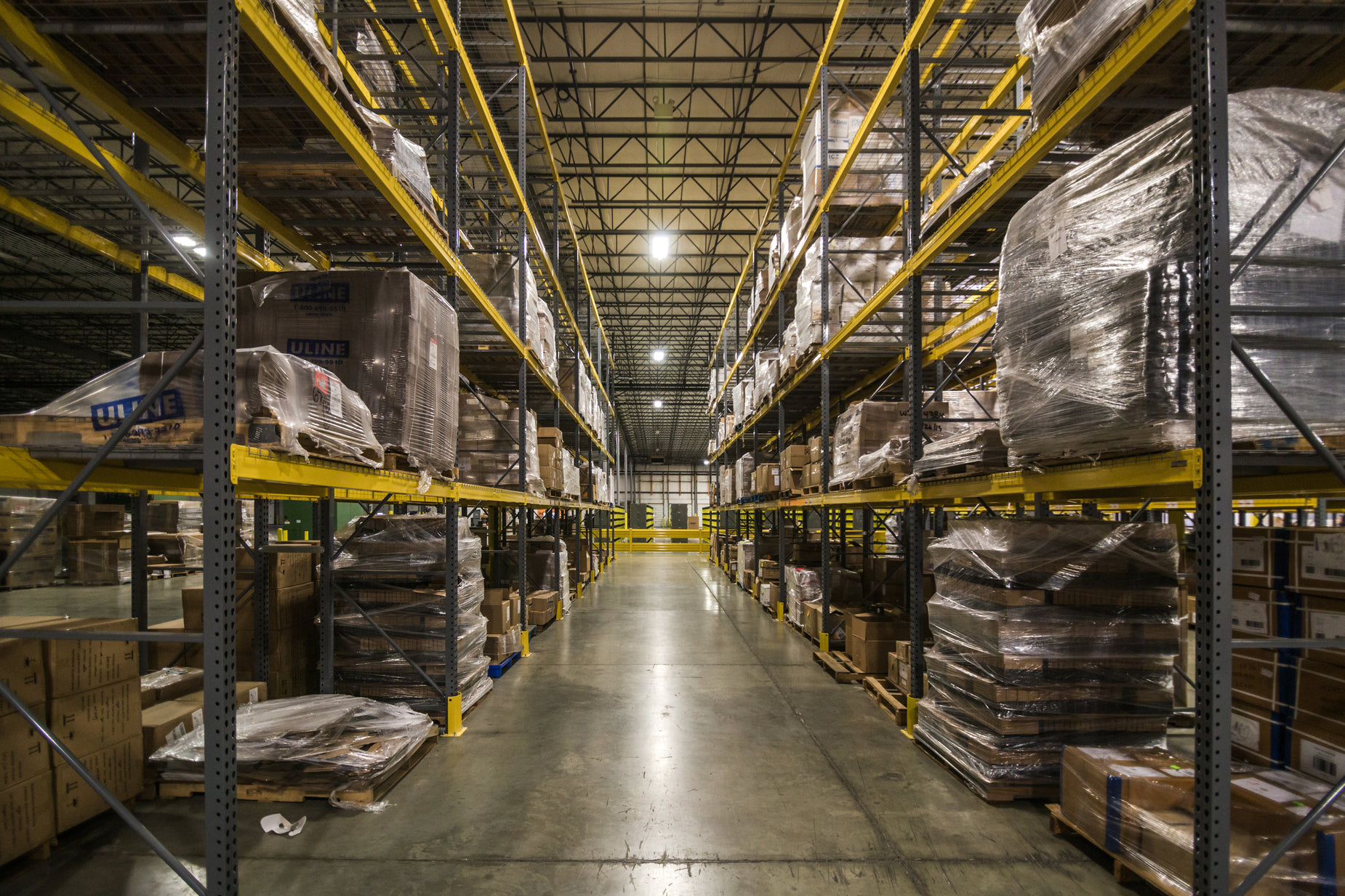 a warehouse with metal shelves filled with wooden boxes