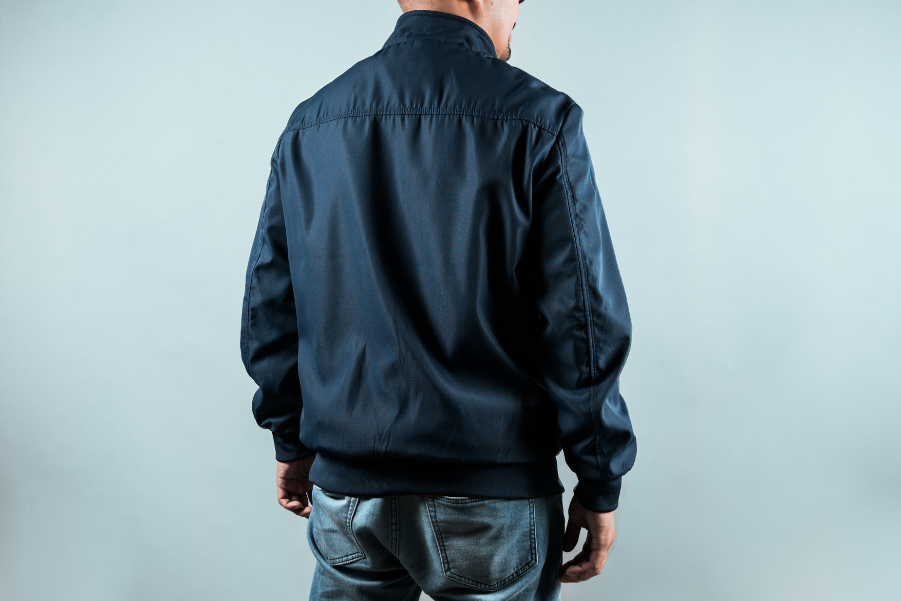 man with short hair in dark blue jeans looking into the distance