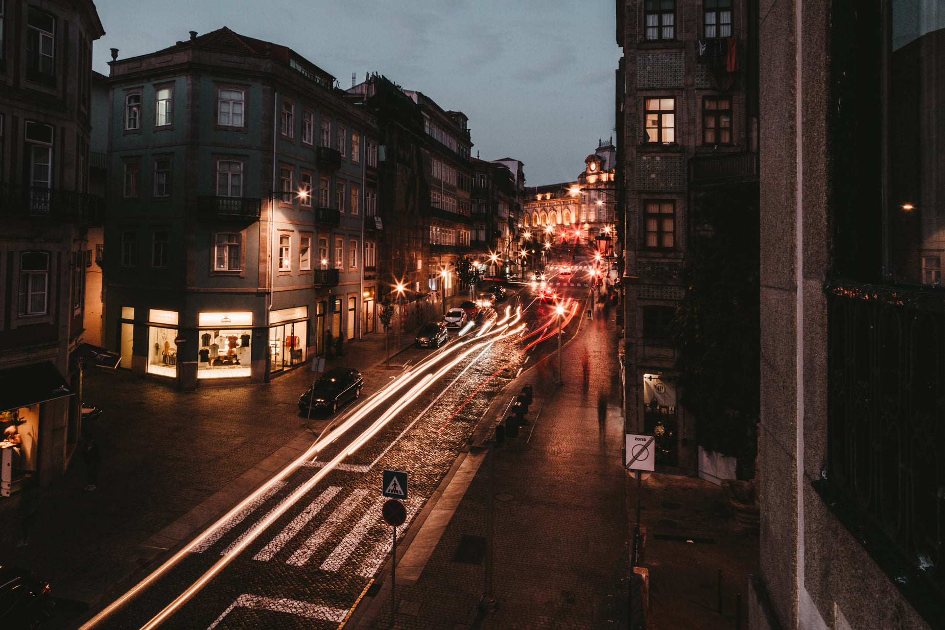 a busy city street at night with a long exposure of traffic going down it