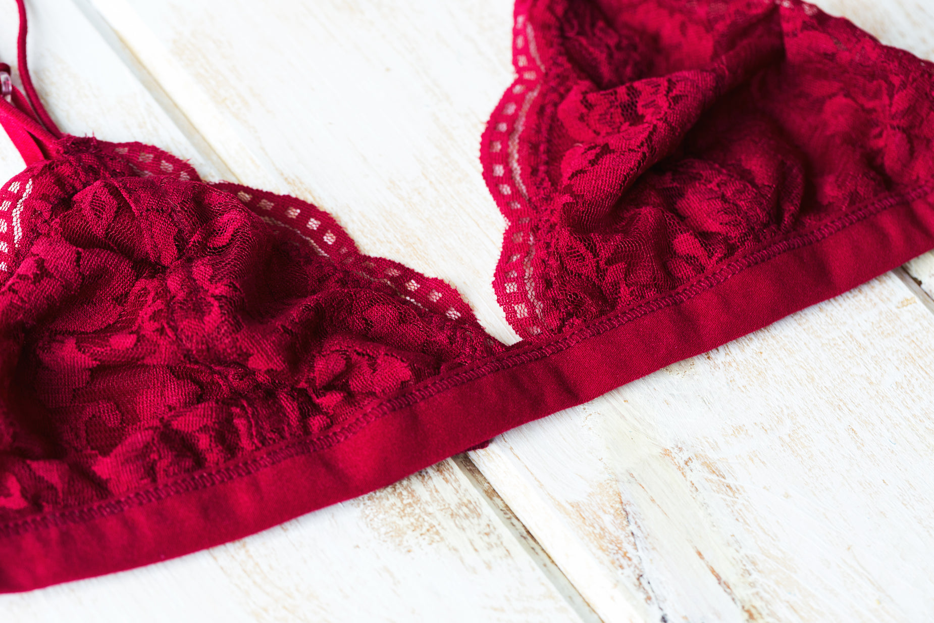 red lingerie laying on white wooden planks