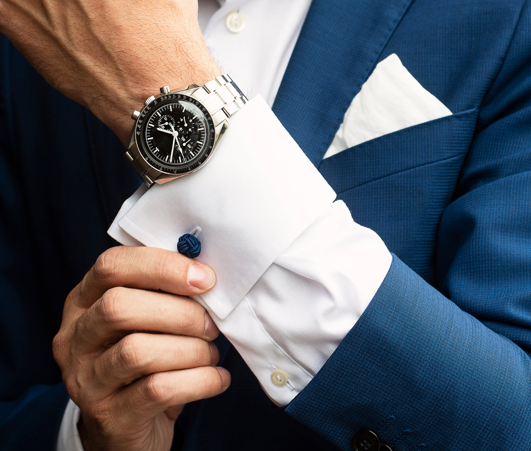 the man wearing a black and silver rolex watch is holding his pocket