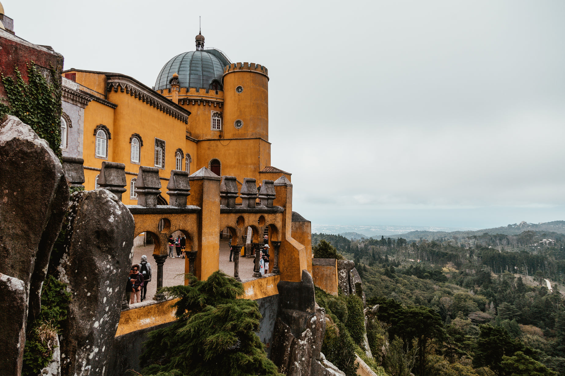 the people are on the balcony of the building on the rocks