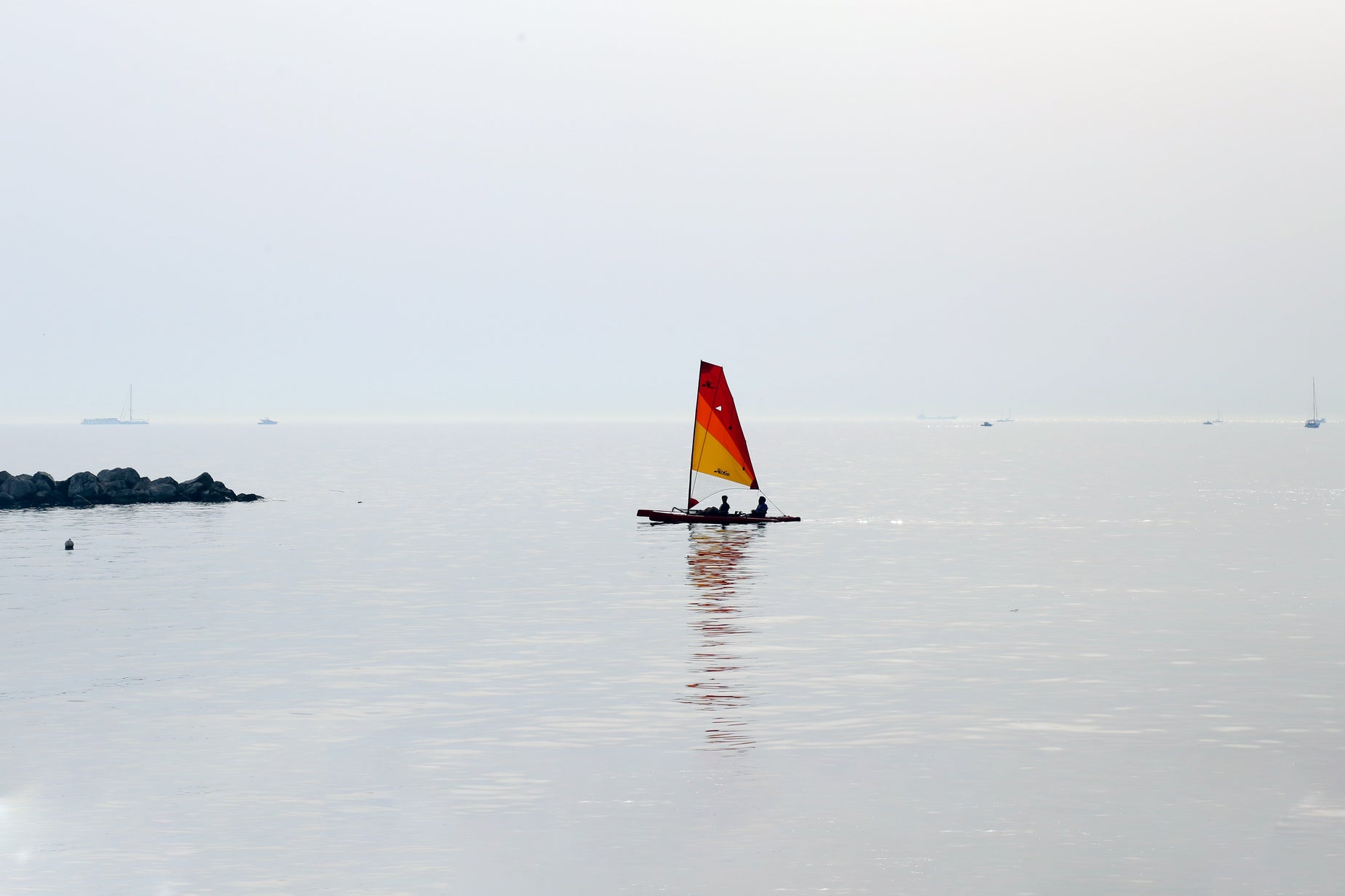 the sailboat is sailing through the water and rocks