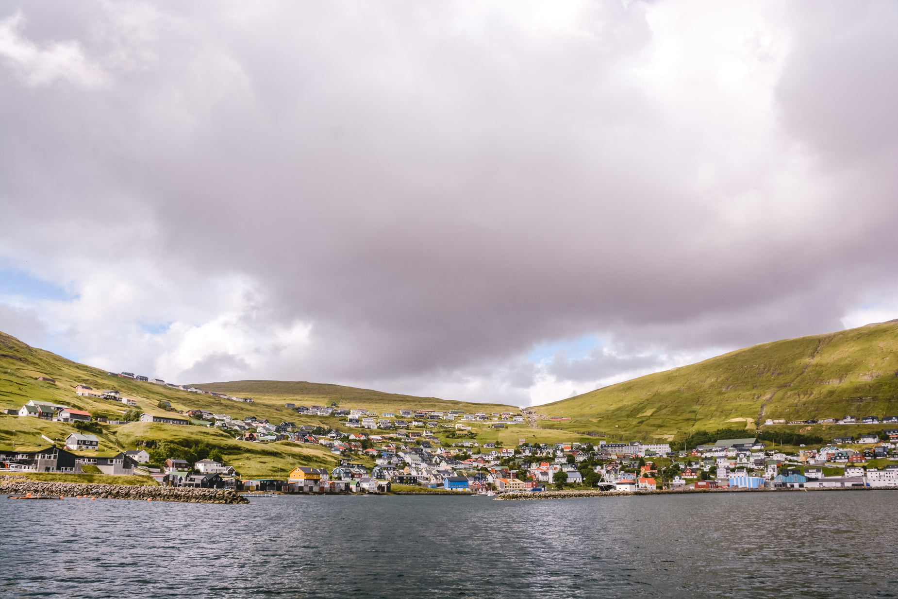 there are many houses on a hill near the water