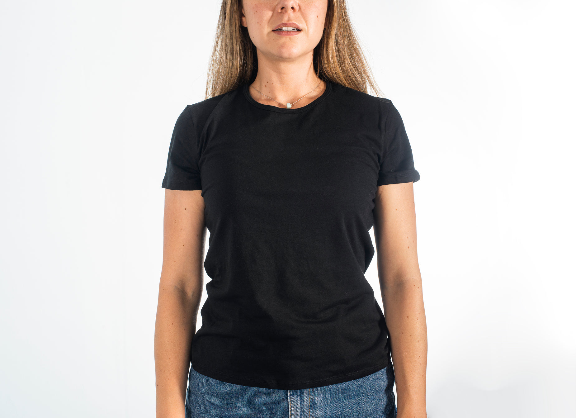 a woman poses for the camera in front of a white background