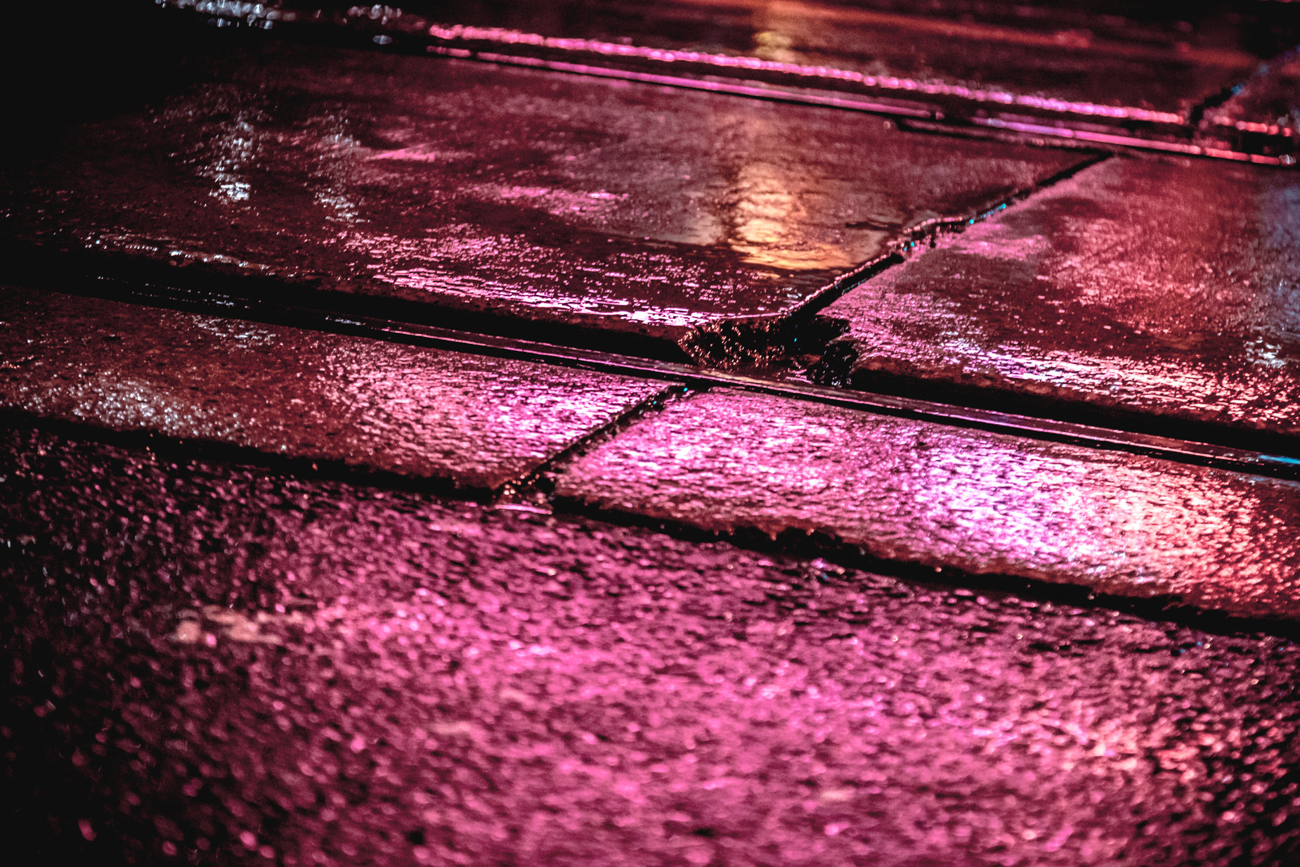 a wet sidewalk with some drops of rain