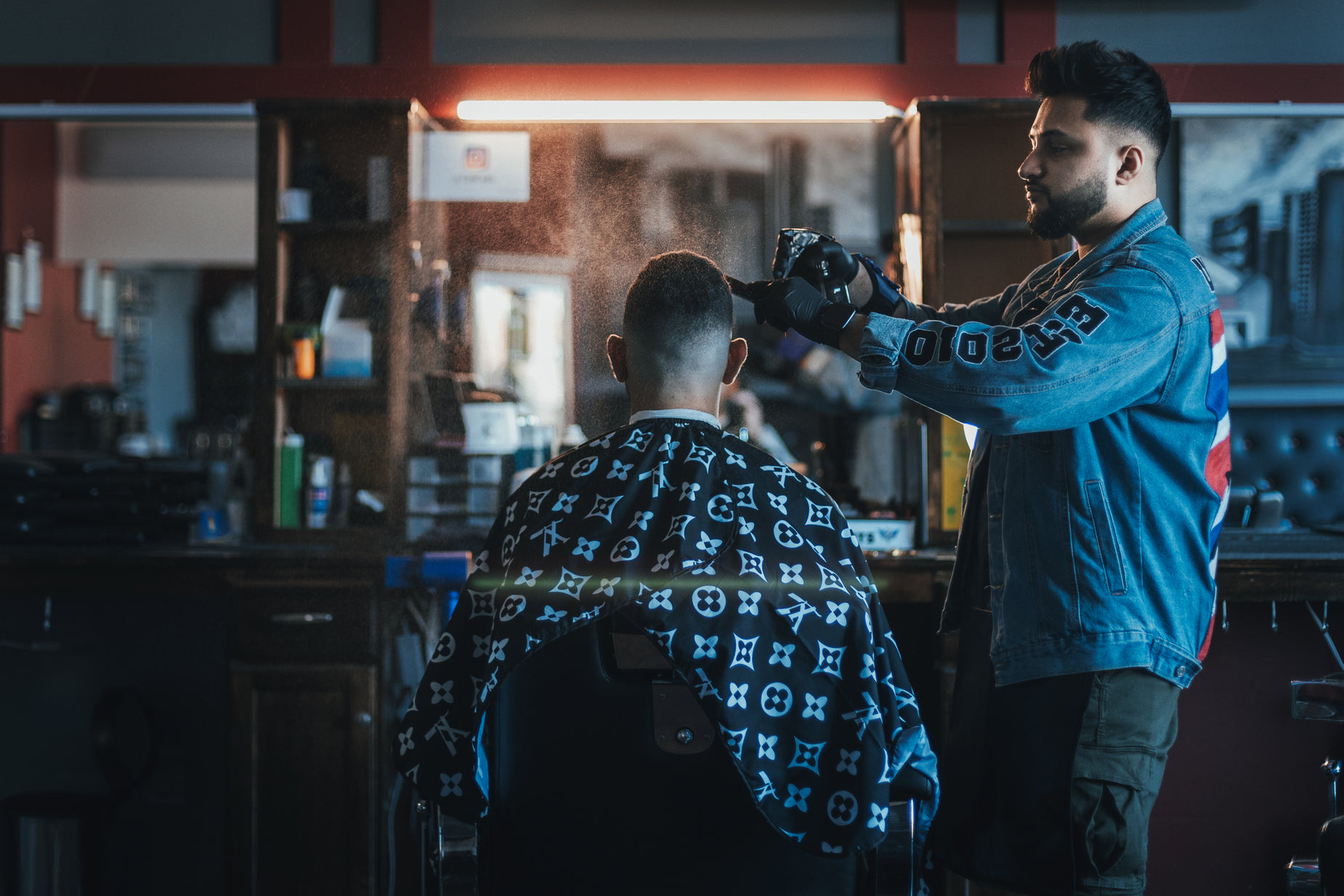 a man getting his haircut by another person in a chair