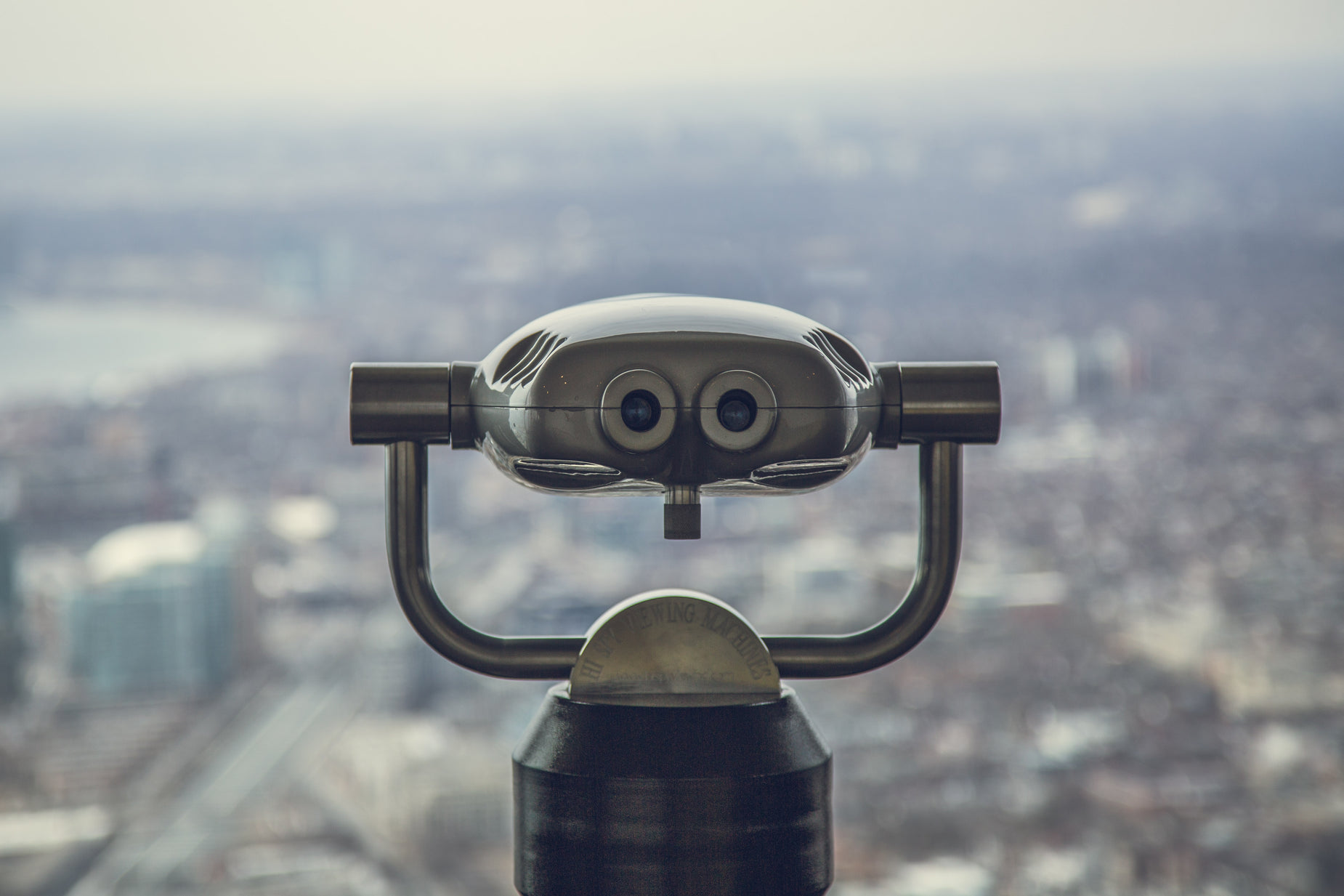 a zoom lens mounted to a silver object over a city