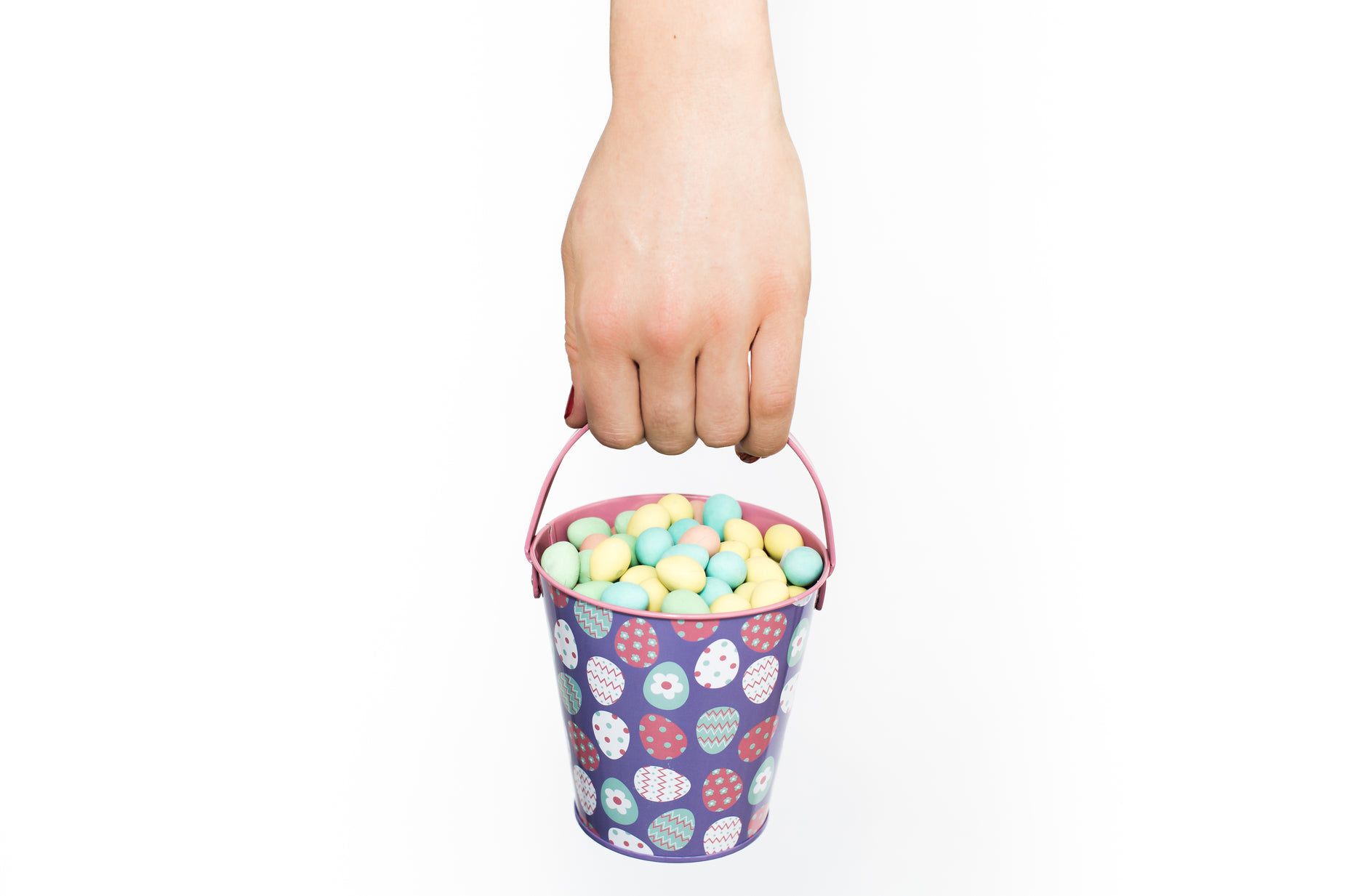 someone is holding a bucket full of easter eggs